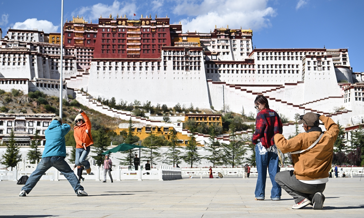 Tourists pose for photos at Potala Palace square in Lhasa, Southwest China's Xizang Autonomous Region on October 15, as the 2026