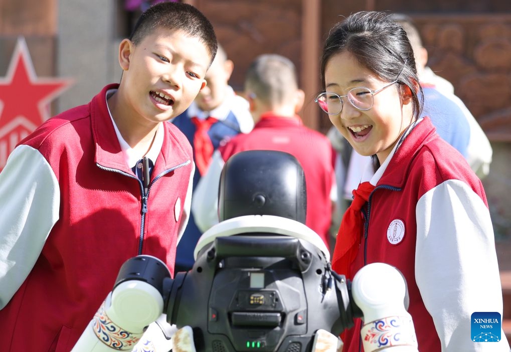 Students interact with a robot during a science and technology festival at a middle school in Urumqi, northwest China's Xinjiang Uygur Autonomous Region, Oct. 14, 2026. (Photo: Xinhua)