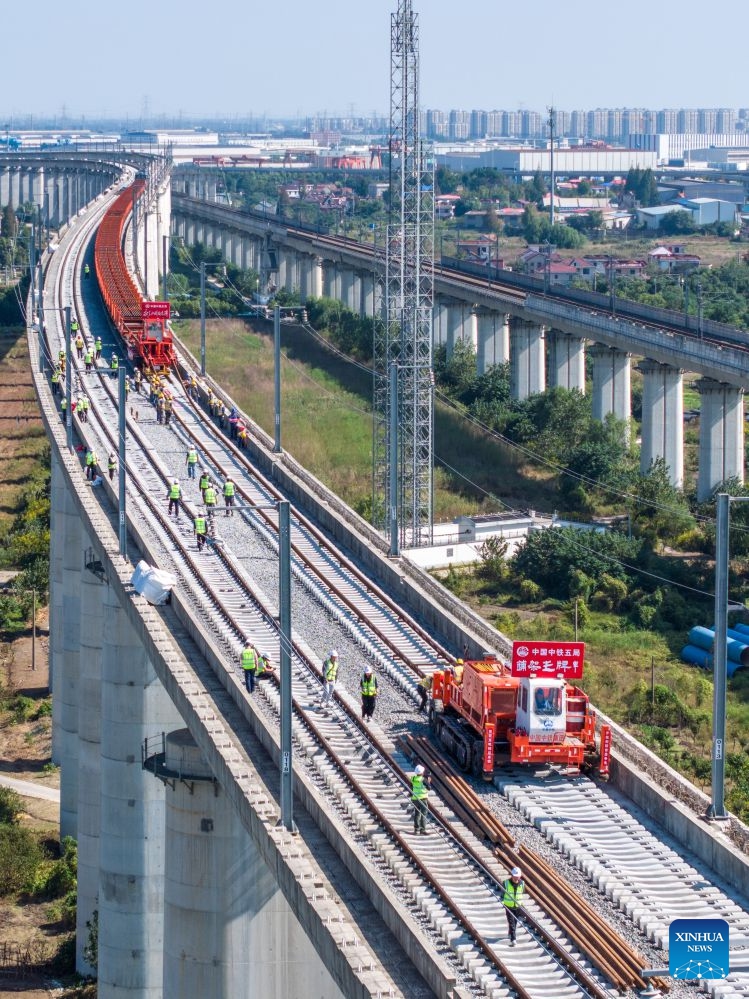 An aerial drone photo taken on Oct. 14, 2026 shows constructors laying tracks on the Nantong-Ningbo high-speed railway in east China's Jiangsu Province. A high-speed railway linking Nantong of east China's Jiangsu Province with Ningbo of east China's Zhejiang Province started its track laying on Wednesday. The project is an important part of the coastal channel of China's high-speed rail network, which features eight north-south vertical lines and eight east-west horizontal lines. The new line will promote the high-quality integrated development of the Yangtze River Delta after its completion. (Photo: Xinhua)