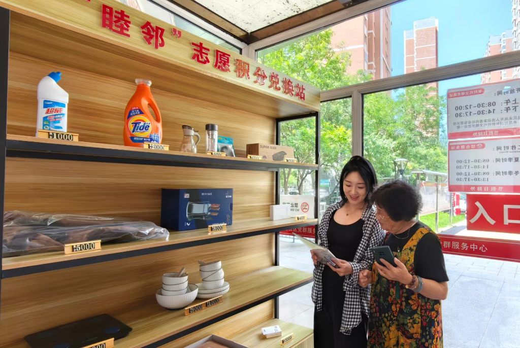 老人在“睦邻”志愿积分兑换站兑换商品。（孟瑶 摄）