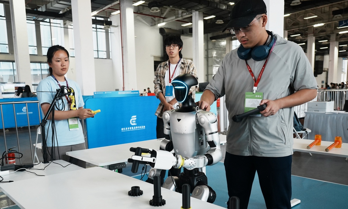 A student remotely controls a Unitree G1 humanoid robot to grasp an object at the inaugural Global Embodied Intelligence Application Innovation Challenge and the 2026 China Robot Competition, which were held in Hangzhou, East China's Zhejiang Province on October 18, 2026. The event drew 2,000 teams and nearly 5,000 university participants, showcasing innovations and skills in embodied intelligence applications. Photo: VCG