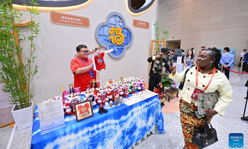 A participant of the 21st Century Maritime Silk Road Local Government Cooperation and International Friendship Cities Dialogue takes photos of a hand puppet play in Fuzhou, southeast China's Fujian Province, Oct. 17, 2026. (Xinhua/Jiang Kehong)