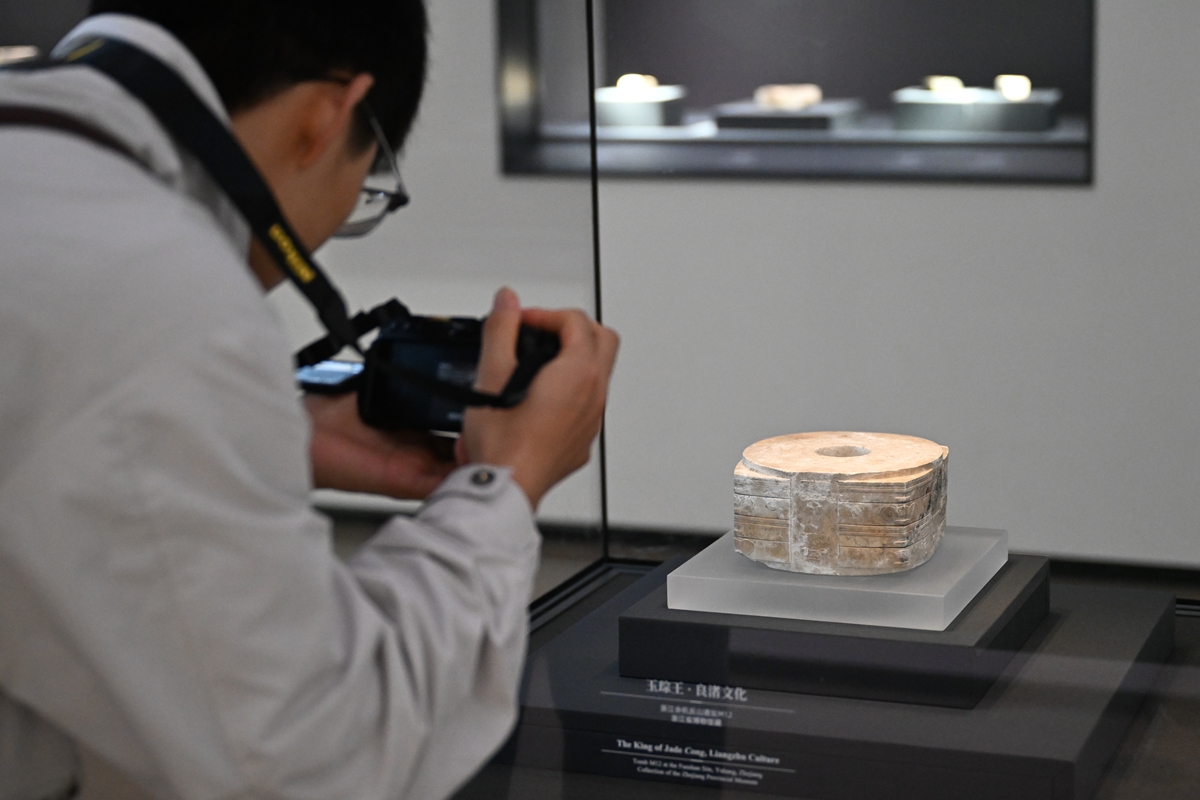 A visitor takes photos of one of the largest jade congs (a ritual object featuring a square outer form and a circular inner tube) at a special exhibition marking the 90th anniversary of the discovery of the Liangzhu archaeological site in Hangzhou, East China's Zhejiang Province, on October 19, 2026. Photo: VCG