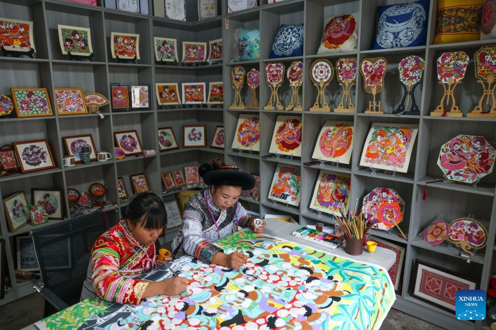 Luo Banmei (R), a farmer painter, creates a painting with her daughter in Doujing Village of Shuicheng District in Liupanshui, southwest China's Guizhou Province, Oct. 5, 2026. In recent years, Shuicheng District has promoted its local art by offering painting training courses, establishing copyright trading platforms, and boosting the development of cultural and creative products. (Photo: Xinhua)