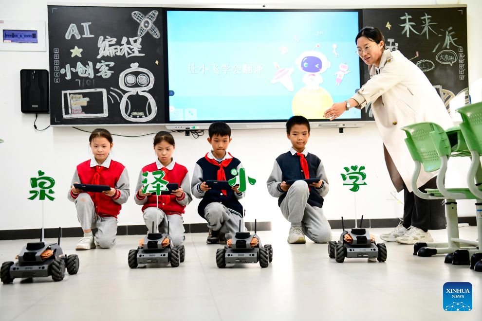 A teacher guides students to train robotic vehicles at a primary school in Jinan, east China's Shandong Province, Oct. 27, 2026. In recent years, Jinan has strengthened science and technology education in primary and secondary schools. Through a rich array of regular sci-tech themed activities, local schools have deeply integrated scientific knowledge into daily teaching to better nurture students' scientific literacy. (Photo: Xinhua)