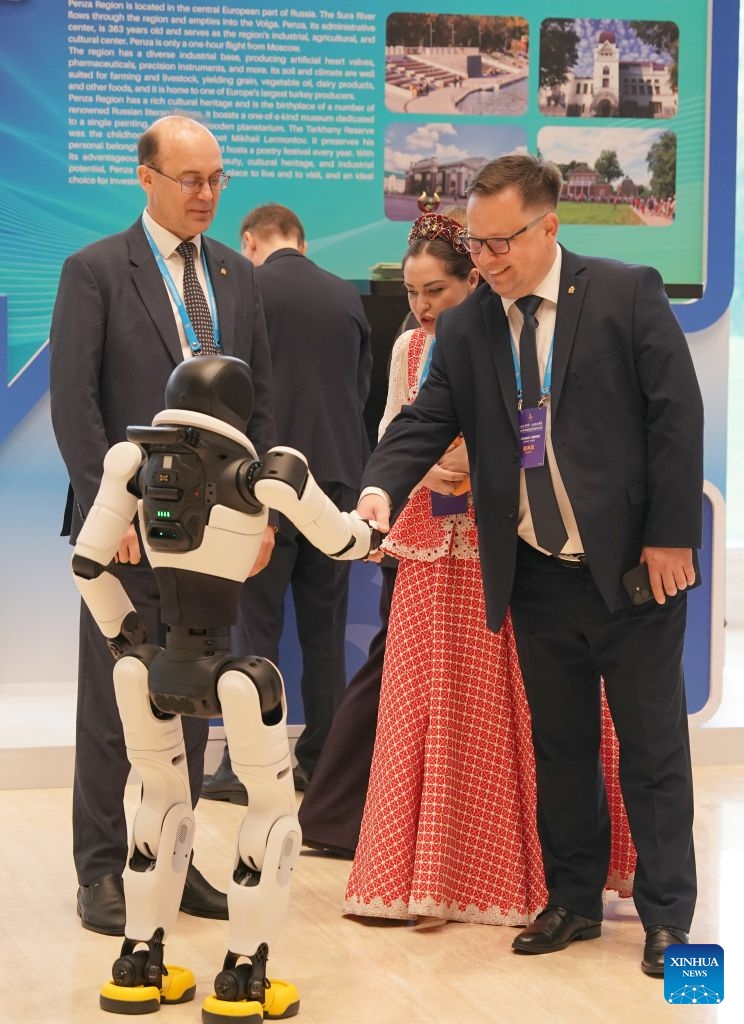 A guest shakes hands with a robot while visiting an exhibition on the sidelines of the opening ceremony of the 2026 China International Friendship Cities Conference in Xi'an, northwest China's Shaanxi Province, on Oct. 21, 2026. Themed Jointly Strengthening Friendship Cities Cooperation for Common Urban Development, the conference kicked off here on Wednesday. (Photo: Xinhua)