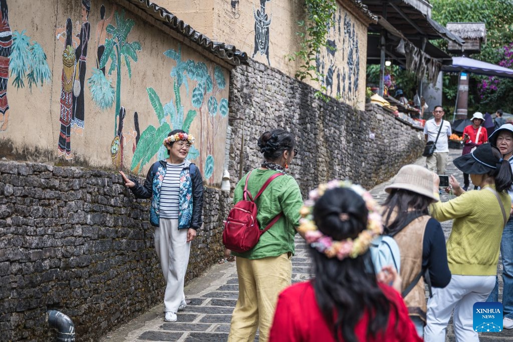 A tourist poses for photos in Simola Wa Village in Qingshui Town of Tengchong City, southwest China's Yunnan Province, Oct. 19, 2026. The Simola Wa Village has a history of over 500 years and is home to people of multiple ethnic groups including the Wa, Han, Bai and Dai. Simola means a place of happiness in the Wa language. In recent years, the village has relied on its ethnic cultural resources to create a distinctive cultural tourism industry, attracting a continuous stream of tourists. (Photo: Xinhua)