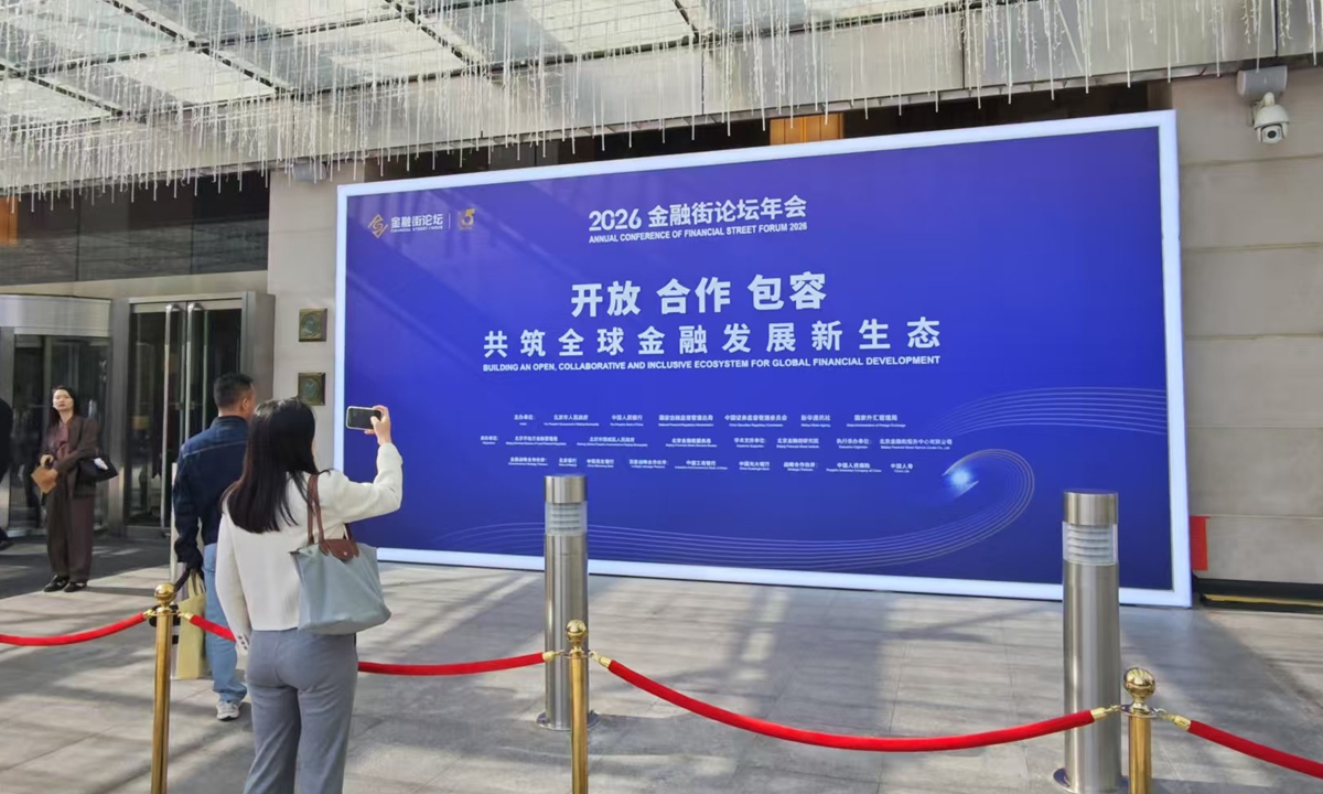 A visitor takes a photo of a display at the Annual Conference of Financial Street Forum 2026 in Beijing on October 20, 2026.  With a theme of 