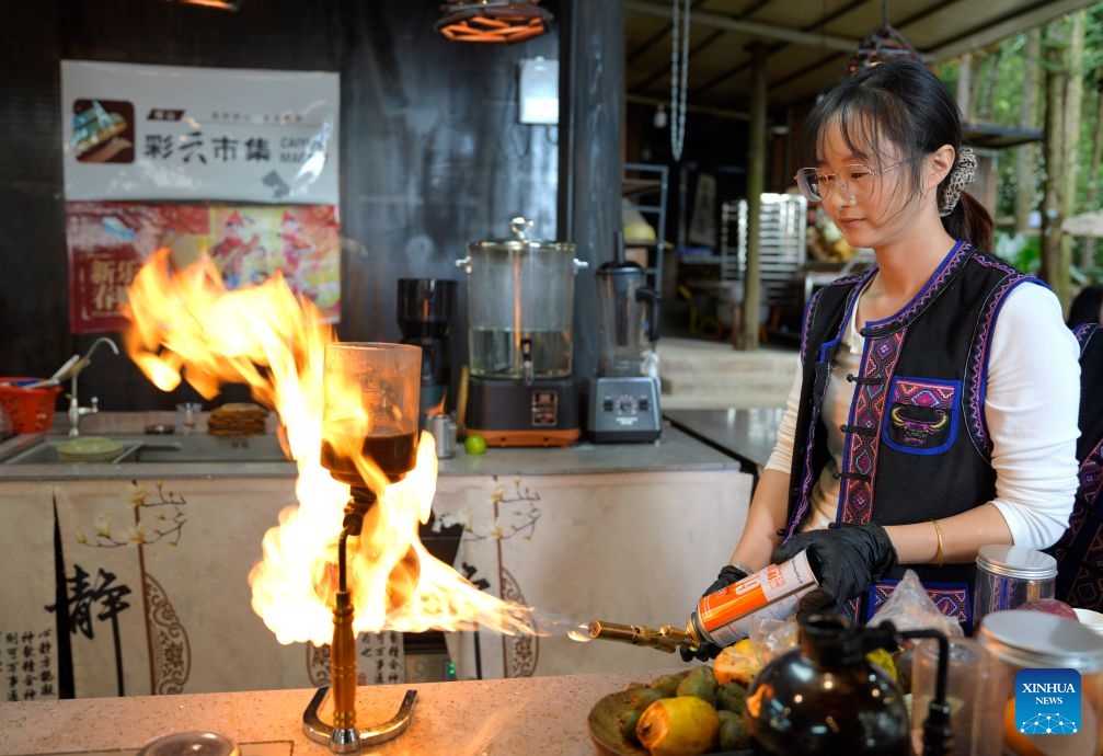 A staff member makes coffee at a cafe in Simola Wa Village in Qingshui Town of Tengchong City, southwest China's Yunnan Province, Oct. 19, 2026. The Simola Wa Village has a history of over 500 years and is home to people of multiple ethnic groups including the Wa, Han, Bai and Dai. Simola means a place of happiness in the Wa language. In recent years, the village has relied on its ethnic cultural resources to create a distinctive cultural tourism industry, attracting a continuous stream of tourists. (Photo: Xinhua)