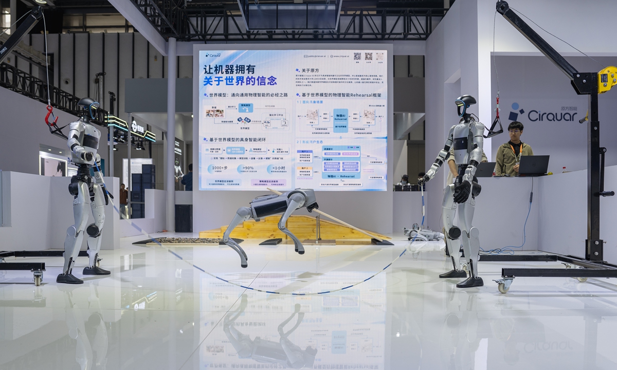 Two humanoid robots swing a long rope for a quadruped robot to skip over at the 2026 Physical AI & World Model Conference in Nanjing, East China's Jiangsu Province, on October 21, 2026. The event gathers experts and showcases cutting-edge intelligent robotic exhibits to explore new frontiers for the AI industry. Photo: VCG