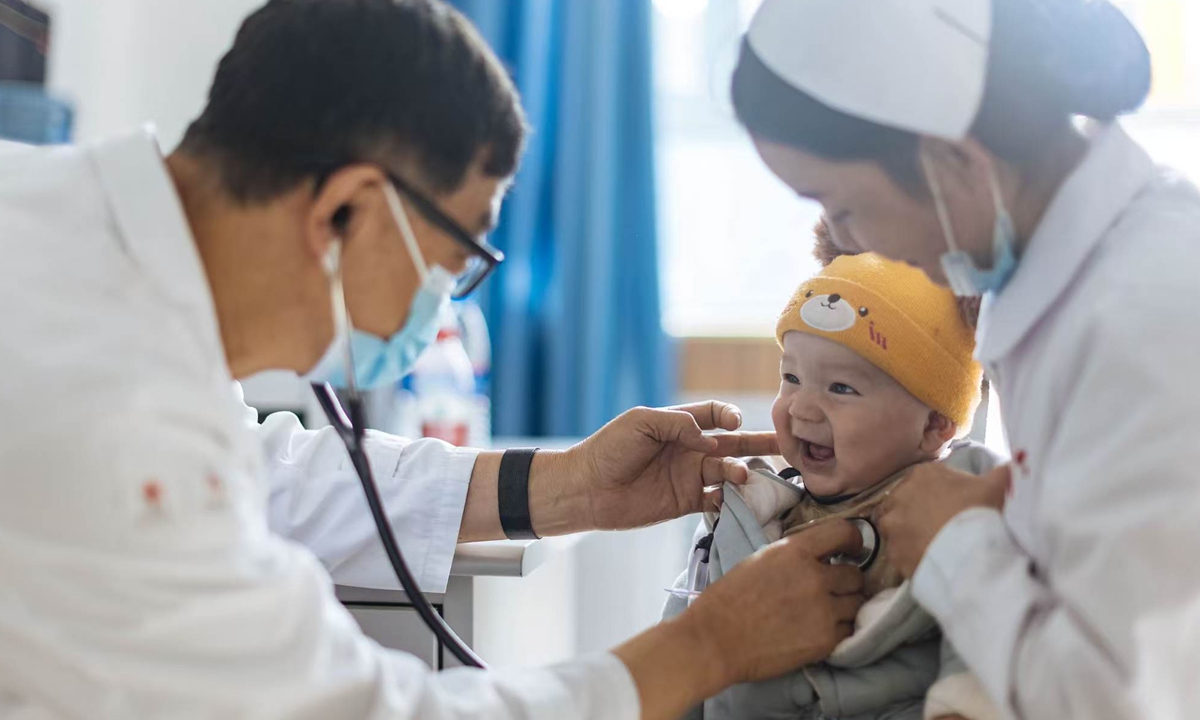 A photo in the exhibition: A volunteer medical team from Shanghai, organized by the Red Cross Society of China, screens local children for congenital heart disease in Kashi, Northwest China's Xinjiang Uygur Autonomous Region, in May 2023. 