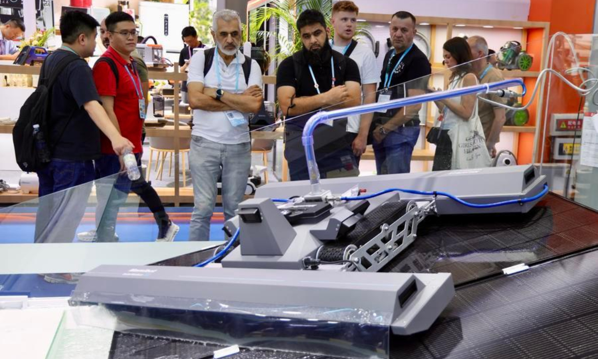Overseas buyers view a solar panel cleaner during the Canton Fair in Guangzhou, south China's Guangdong Province, Oct. 15, 2026. (Xinhua/Lu Hanxin)