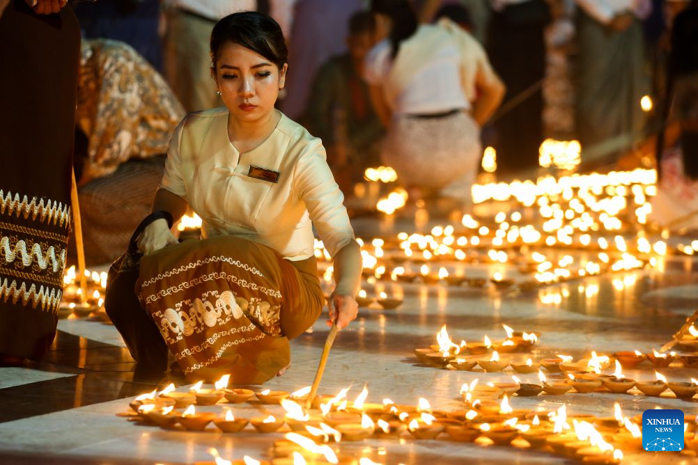 A woman lights candles on the full moon day of Thadingyut festival at the Botahtaung Pagoda in Yangon, Myanmar, Oct. 26, 2026. (Xinhua/Myo Kyaw Soe)