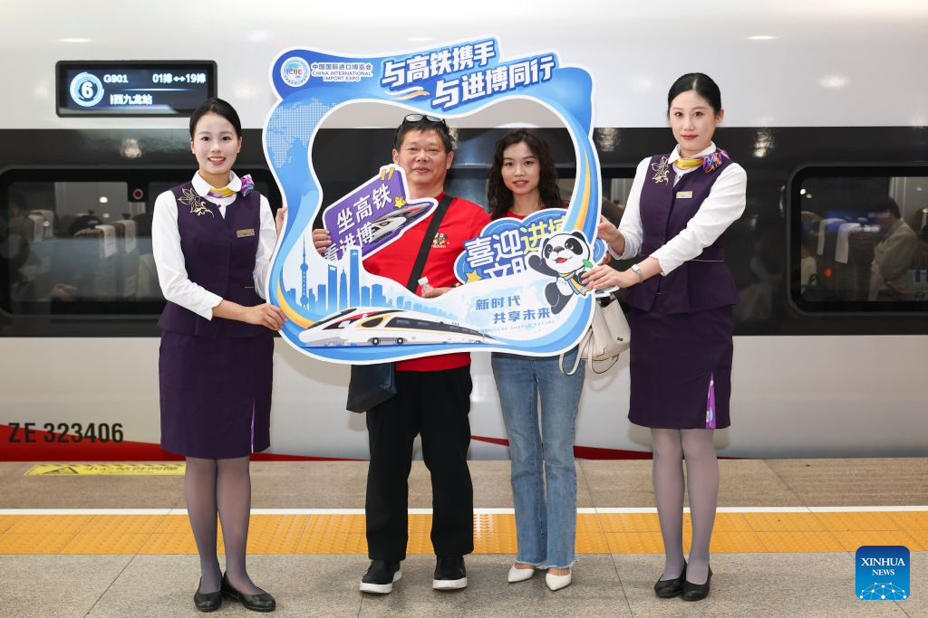 Passengers pose for photos behind a frame prop promoting the upcoming 9th China International Import Expo (CIIE) at the platform of Shanghai Hongqiao Railway Station in east China's Shanghai, Oct. 28, 2026. A promotion activity was held on the train G901 on Wednesday to show highlights of this year's CIIE, which will be held in Shanghai from Nov. 5 to 10. (Xinhua/Wang Xiang)