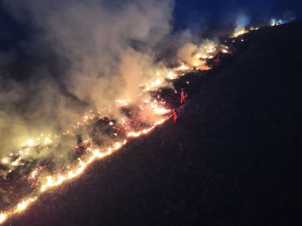 An aerial drone photo taken on Oct. 11, 2026 shows firefighters extinguishing a grassland fire at the border area in north China's Inner Mongolia Autonomous Region. (Xinhua)