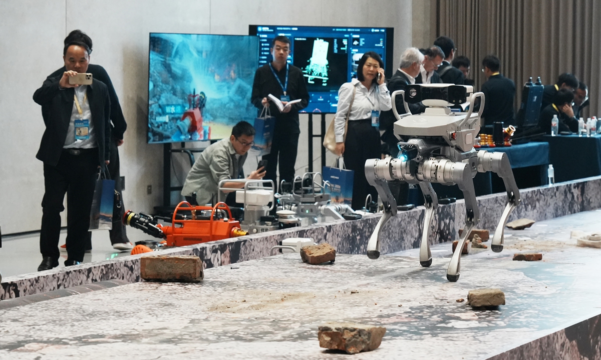 Visitors watch a robotic dog perform reconnaissance in a simulated complex environment at the 2026 World Physical AI Conference held in Hangzhou, East China's Zhejiang Province, on October 22, 2026. On-site displays featured the latest technologies from Unitree Robotics, including AI cluster demos and intelligent guidance functions for its humanoid robots such as the G1 and H2-X. Photo: VCG