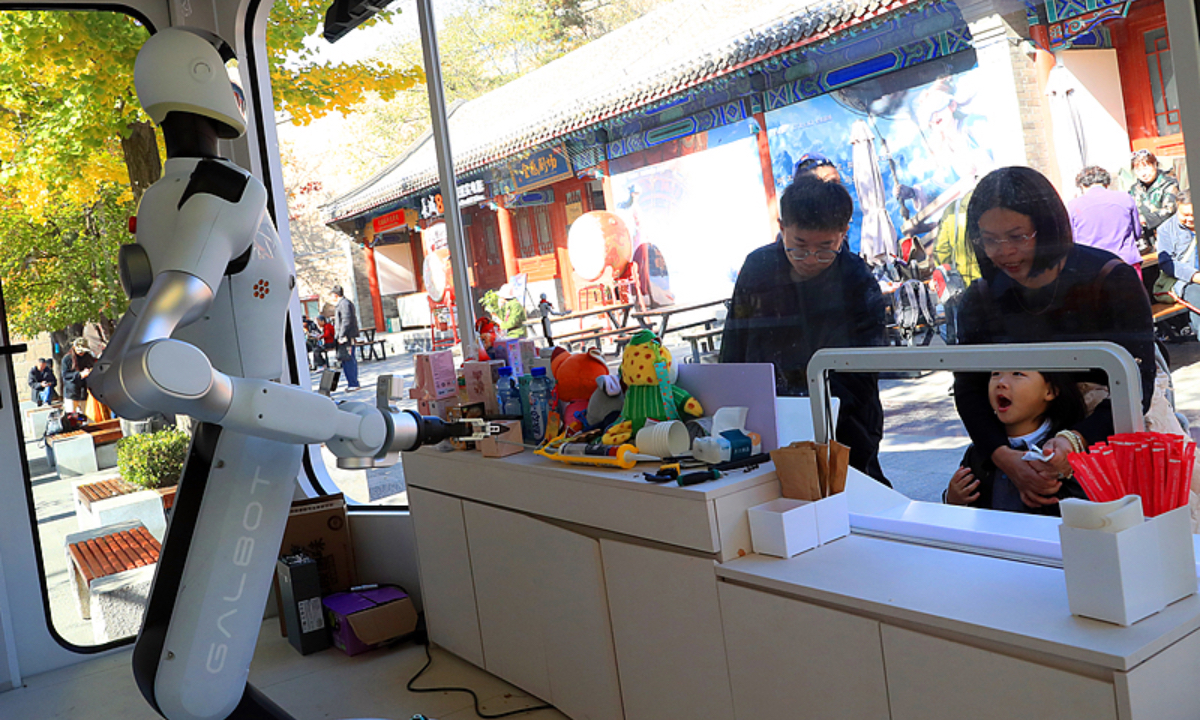 A humanoid robot greets passers-by and serves customers a “space capsule,” intriguing the visitors at Beijing’s Badaling Great Wall on October 28, 2026. Photo: VCG