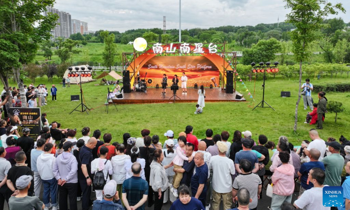 People watch performances at a city park in Hegang City, northeast China's Heilongjiang Province, June 20, 2026. (Xinhua)