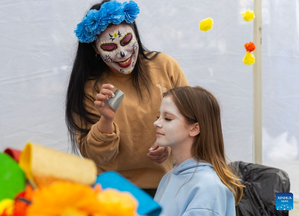 A girl gets Catrina-themed face painting at Catrinas Festival Canada 2026 in Toronto, Canada, on Oct. 25, 2026. The annual Catrinas Festival was held here from Oct. 24 to 25, showcasing Mexican Day of the Dead (Día de Muertos) cultural traditions. (Photo by Zou Zheng/Xinhua)