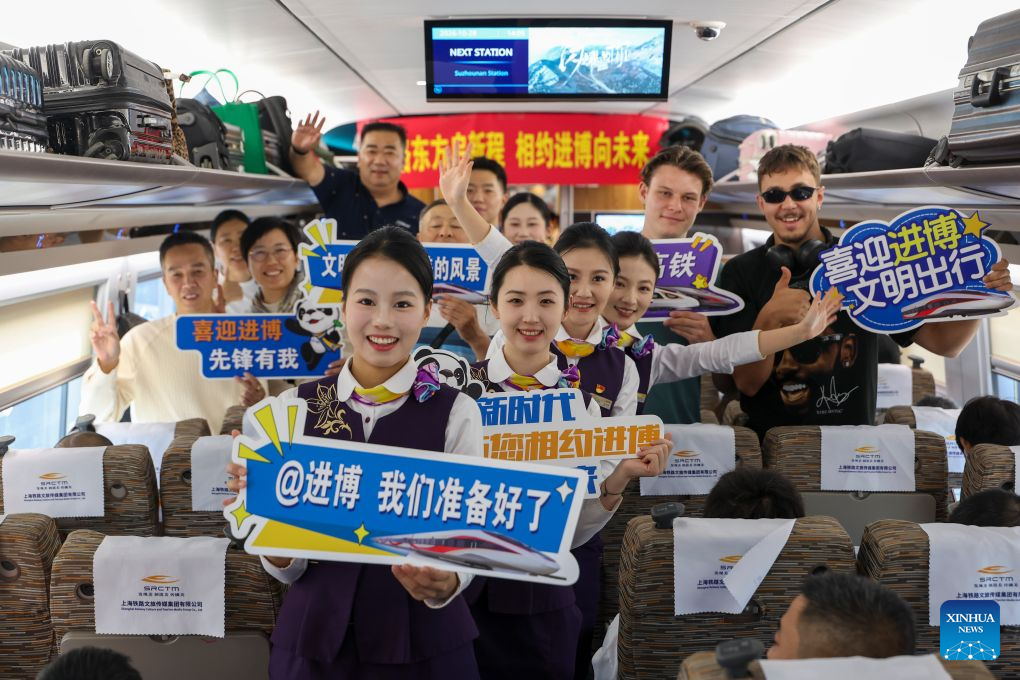 Passengers pose for group photos with staff members during an activity promoting the upcoming 9th China International Import Expo (CIIE) on the train G901, Oct. 28, 2026. A promotion activity was held on the train G901 on Wednesday to show highlights of this year's CIIE, which will be held in Shanghai from Nov. 5 to 10. (Xinhua/Wang Xiang)