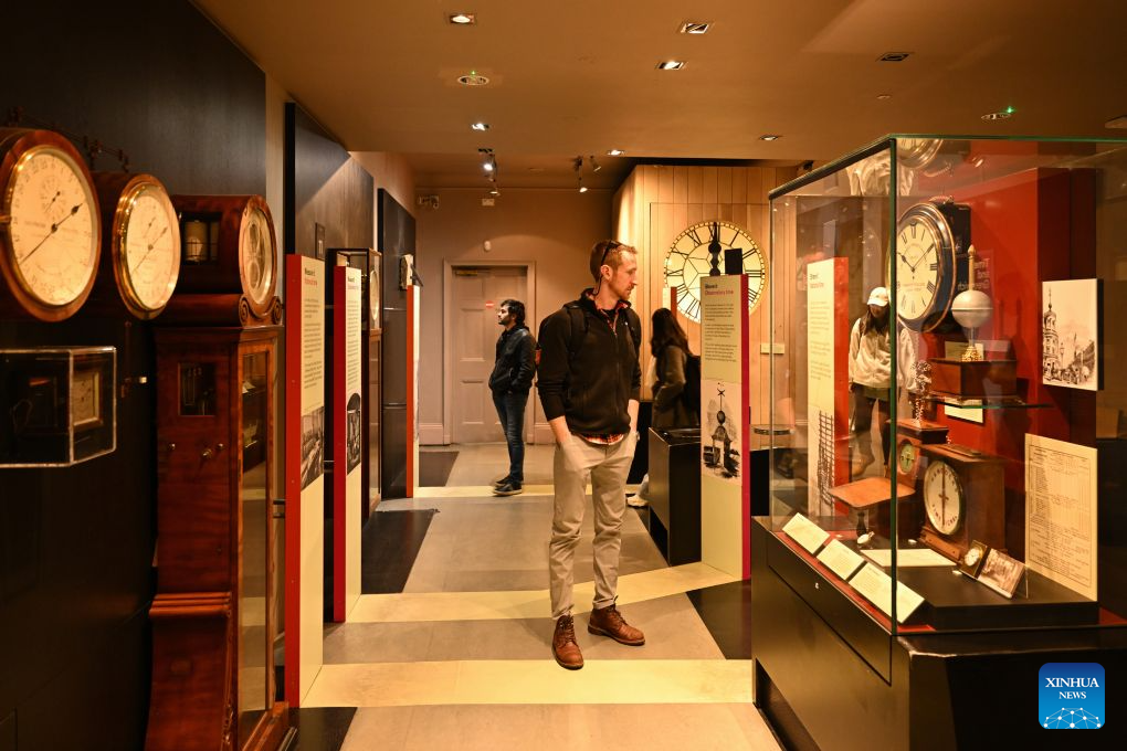 Visitors look at exhibits themed on Greenwich Mean Time at the Royal Observatory in Greenwich, London, Britain, on Oct. 25, 2026. The Royal Observatory in Greenwich was founded in 1675 to improve navigation at sea through astronomical observations and help ships determine their longitude. As the home of Greenwich Mean Time, it holds an important place in the history of astronomy, precision timekeeping and navigation. In 1884, the meridian passing through the observatory was adopted as the international Prime Meridian, establishing a common reference for measuring longitude worldwide. This historic line is still marked at the observatory today. (Xinhua/Li Mangmang)