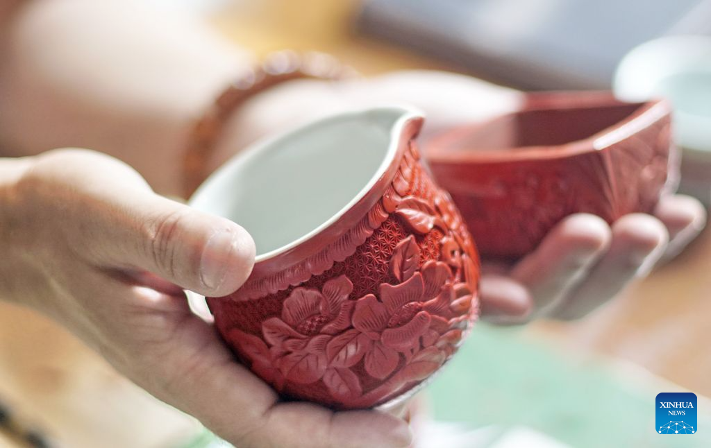 Zhu Jiang (R) shows his pieces of work of the carved lacquer craft on porcelain body in Beijing, capital of China, Oct. 24, 2026.

Born in 1976, Zhu Jiang, a master of arts and crafts of Beijing, is an inheritor of the carved lacquer art.

The carved lacquer craft on porcelain body is a unique art form that combines two traditional Chinese crafts, porcelain and carved lacquerware making, into a single piece.

Through years of studying and practicing, Zhu has overcome a series of difficulties to achieve a better presentation of this craft. (Photo by Zhang Xiaotan/Xinhua)