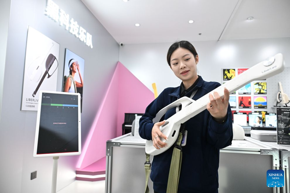 A staff member plays a stringless guitar at the AI Intelligent Terminal Consumption Center in the Nanjing AI Agent Distribution Center in Nanjing, east China's Jiangsu Province, Oct. 26, 2026.
The Nanjing AI Agent Distribution Center is an integrated platform for the display and supply-demand matching of AI applications and technologies. (Xinhua/Ji Chunpeng)