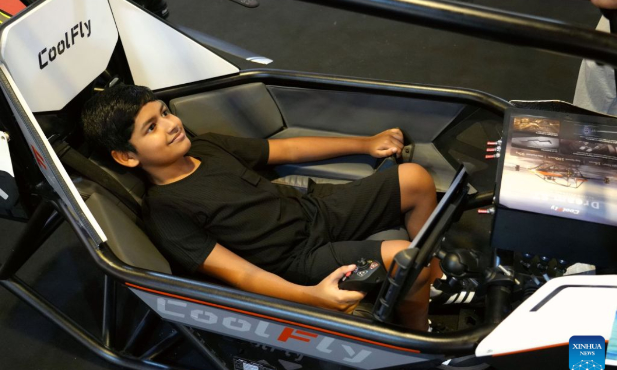 A teenager tries out a Chinese manned aerial vehicle at Maldives Expo 2026, in Male, Maldives, Oct. 27, 2026. The expo attracted approximately 430 exhibitors, showcasing more than 4,400 exhibits across seven themed exhibition zones. Twelve Chinese enterprises participated in the event, bringing new opportunities for Maldivian SMEs to enhance operational efficiency and expand international cooperation. (Xinhua/Xu Han)