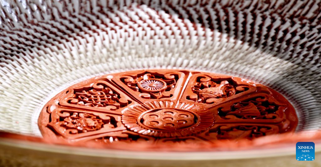 This photo taken on Oct. 26, 2026 shows a piece of Zhu Jiang's work of the carved lacquer craft on porcelain body in Beijing, capital of China.

Born in 1976, Zhu Jiang, a master of arts and crafts of Beijing, is an inheritor of the carved lacquer art.

The carved lacquer craft on porcelain body is a unique art form that combines two traditional Chinese crafts, porcelain and carved lacquerware making, into a single piece.

Through years of studying and practicing, Zhu has overcome a series of difficulties to achieve a better presentation of this craft. (Xinhua/Li Xin)
