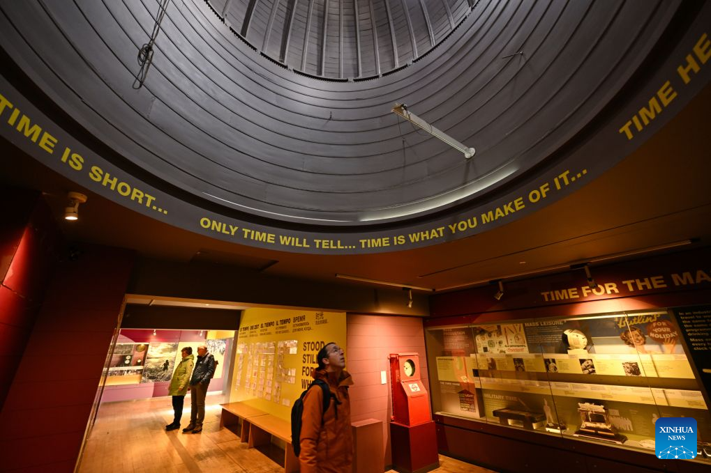 A visitor views a time-themed exhibition at the Royal Observatory in Greenwich, London, Britain, on Oct. 25, 2026. The Royal Observatory in Greenwich was founded in 1675 to improve navigation at sea through astronomical observations and help ships determine their longitude. As the home of Greenwich Mean Time, it holds an important place in the history of astronomy, precision timekeeping and navigation. In 1884, the meridian passing through the observatory was adopted as the international Prime Meridian, establishing a common reference for measuring longitude worldwide. This historic line is still marked at the observatory today. (Xinhua/Li Mangmang)
