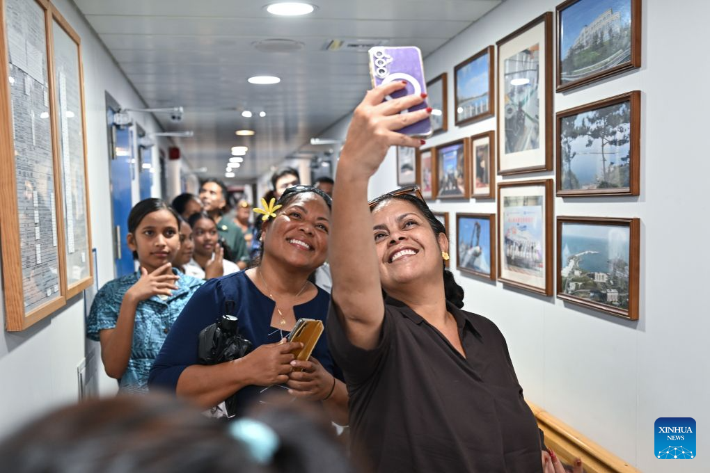 Local residents take a selfie during a tour aboard China's research vessel Deep Sea No. 1 berthed at Aiwo Port in Naoero, Oct. 26, 2026.
China's research vessel Deep Sea No. 1, carrying manned deep-sea submersible Jiaolong, on Monday visited Naoero and held an ocean-themed open day event here. (Xinhua/Li Xin)