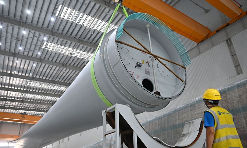 A wind turbine blade is hoisted for installation in Dongfang base of Ming Yang Smart Energy Group in Dongfang City, south China's Hainan Province, Oct. 22, 2026. In recent years, Hainan has continued to advance the development and utilization of clean energy, actively fostered the green energy manufacturing industry, and promoted the green transition of energy and industrial upgrading. (Xinhua/Guo Cheng)