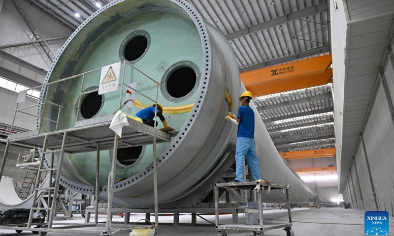 Staff members carry out shaping work on a wind turbine blade in Dongfang base of Ming Yang Smart Energy Group in Dongfang City, south China's Hainan Province, Oct. 22, 2026. In recent years, Hainan has continued to advance the development and utilization of clean energy, actively fostered the green energy manufacturing industry, and promoted the green transition of energy and industrial upgrading. (Xinhua/Guo Cheng)