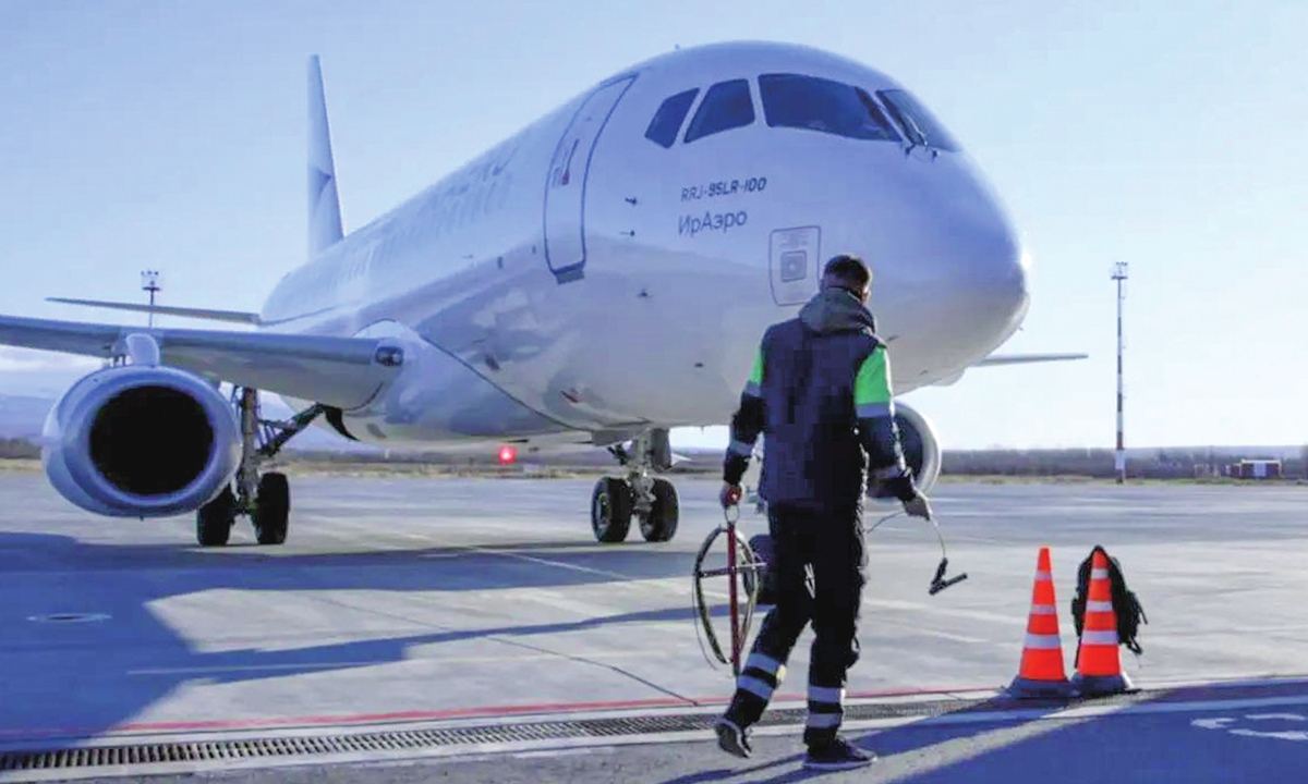 A worker passes by an aircraft at the Yelizovo International Airport in Petropavlovsk-Kamchatsky, Russia, on October 24, 2026, as IrAero launches direct regular flights between the city and Harbin in Northeast China's Heilongjiang Province. The service will be operated using a Sukhoi Superjet aircraft once a week on Saturdays. Photo: VCG