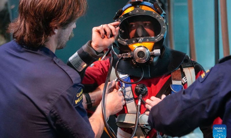 A Canadian Coast Guard diver adjusts diving equipment with assistance during Divers' Weekend at the Vancouver Aquarium in Vancouver, British Columbia, Canada, on Oct. 24, 2026. The two-day event, which opened here on Saturday, brings together diving professionals and organizations and features diving equipment displays, underwater demonstrations and expert talks aimed at promoting diving safety and preparedness. (Photo by Liang Sen/Xinhua)