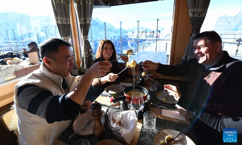 This file photo taken on Dec. 18, 2025 shows visitors enjoying Swiss cheese fondue in a restaurant at Grindelwald-First mountain in the canton of Bern, Switzerland. (Xinhua/Lian Yi)