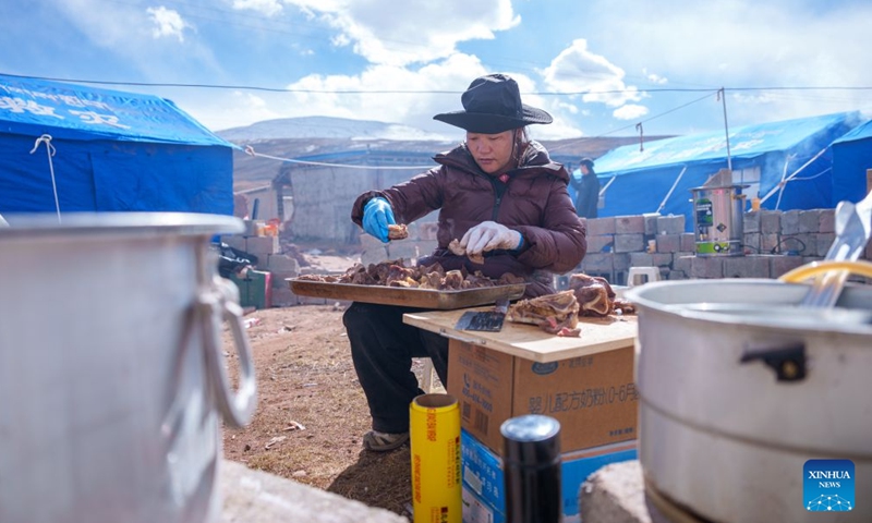 A staff member of the local government prepares food at a quake-hit village in Maru Township of Baqen County, Nagqu City, southwest China's Xizang Autonomous Region, Oct. 24, 2026. As of 11 a.m. Saturday, 52,450 items or sets of disaster relief supplies had been sent to the quake zone, while more than 2,500 rescue personnel were engaged in relief operations.
Authorities have established 35 temporary resettlement sites in the disaster zone. Medical treatment and public health and epidemic prevention efforts are proceeding in an orderly manner, according to the local emergency command headquarters. (Xinhua/Tenzin Nyida)