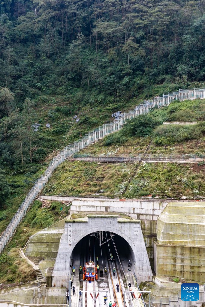An aerial drone photo taken on Oct. 24, 2026 shows the construction site at the Junlian tunnel of the Chongqing-Kunming high-speed railway on the border of southwest China's Yunnan Province and southwest China's Sichuan Province. The last pair of 500-meter-long steel rails was steadily placed on the track on Saturday, marking the official completion of track laying for the Chongqing-Kunming high-speed railway. (Xinhua/Hu Chao)