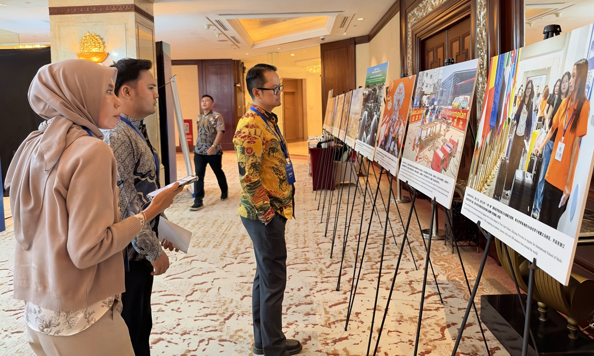 Three Indonesian visitors look at the photos at the Global Times' photo exhibition in Jakarta on October 19, 2026. Photo: Zhang Han/GT