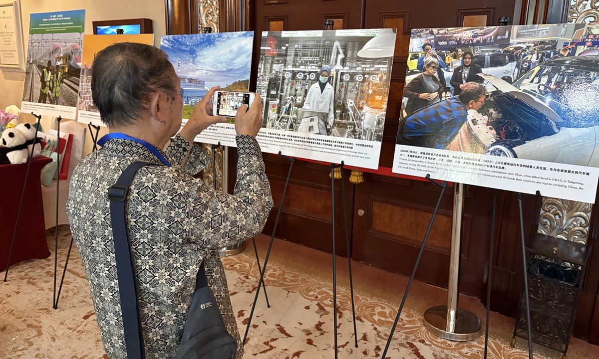 An Indonesian visitor takes a picture at the photos at the Global Times' photo exhibition in Jakarta on October 19, 2026. Photo: Wang Wenwen/GT