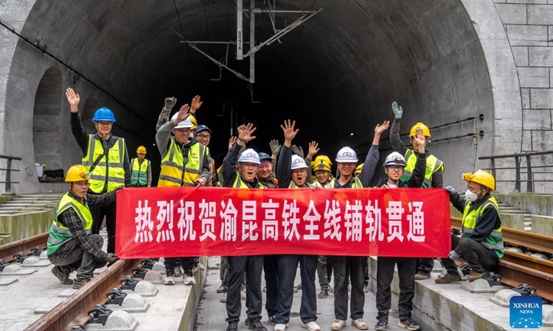 Workers pose for photos to celebrate the completion of track laying at the Junlian tunnel of the Chongqing-Kunming high-speed railway on the border of southwest China's Yunnan Province and southwest China's Sichuan Province, Oct. 24, 2026. The last pair of 500-meter-long steel rails was steadily placed on the track on Saturday, marking the official completion of track laying for the Chongqing-Kunming high-speed railway. (Xinhua/Hu Chao)
