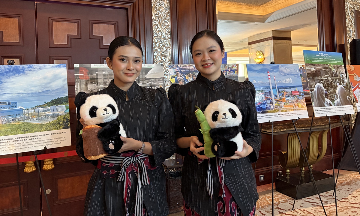 Two Indonesian visitors pose for a photo, holding panda dolls, at the Global Times' photo exhibition in Jakarta on October 19, 2026. Photo: Yu Jincui/GT