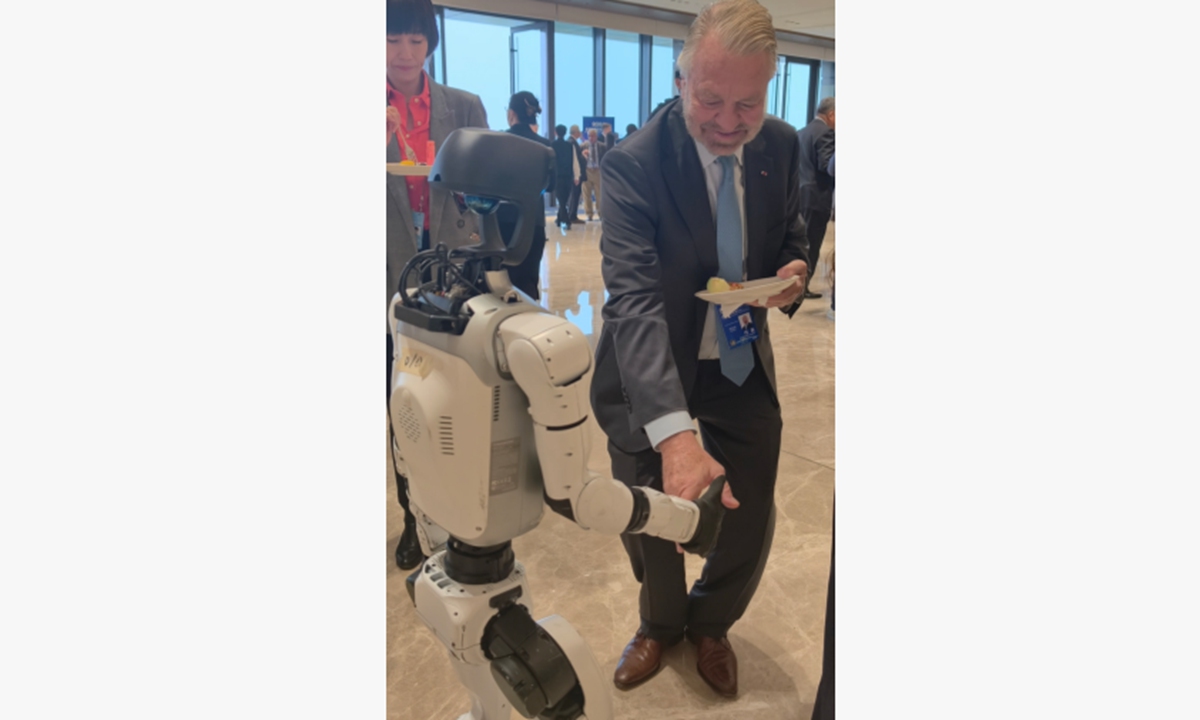 A foreign guest shakes hands with a robot at the Global Governance Forum in Xiong'an New Area, North China's Hebei Province, on October 24, 2026. Photo: Hu Yuwei/Global Times