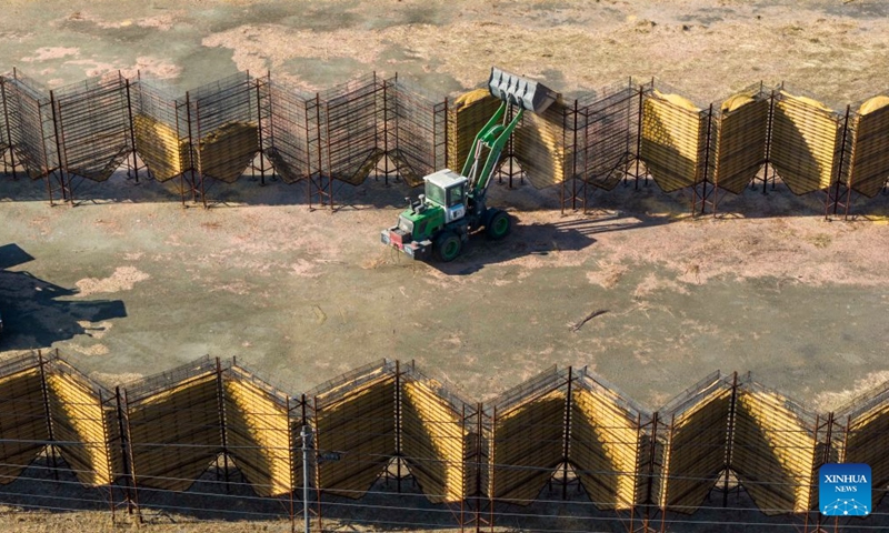 A drone photo taken on Oct. 25, 2026 shows a shovel loader pouring the corn into a natural ventilation drying rack at a grain procurement and storage company in Jixian County of Shuangyashan City, northeast China's Heilongjiang Province. With the autumn harvest drawing to an end in Heilongjiang, China's top grain-producing province, all grain-growing areas in the province are stepping up post-harvest management to ensure safe grain storage and procurement. (Photo by Han Yang/Xinhua)