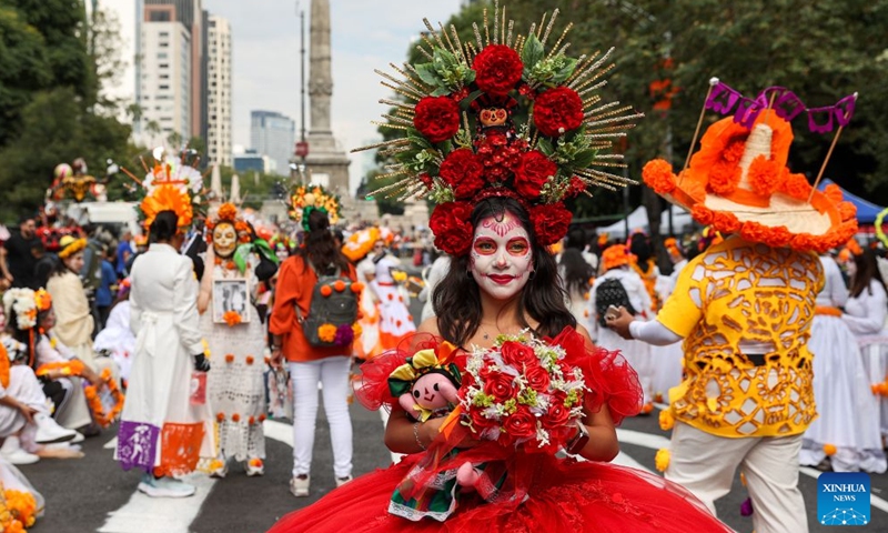 A woman with facial makeup prepares to take part in the Catrinas Parade in Mexico City, capital of Mexico, on Oct. 25, 2026. The Catrinas Parade was held on Sunday ahead of the Day of the Dead. (Xinhua/Ding Hongfa)