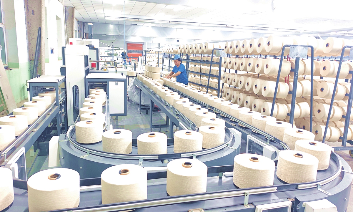 Workers produce yarn at a textile company in Awati county, Northwest China's Xinjiang Uygur Autonomous Region, on October 27, 2026. The company has been operating at full capacity to fulfill orders and meet market demand. In recent years, Awati county has promoted the upgrading of its textile industry through technological innovation, equipment renewal and the introduction of intelligent production lines. Photo: VCG