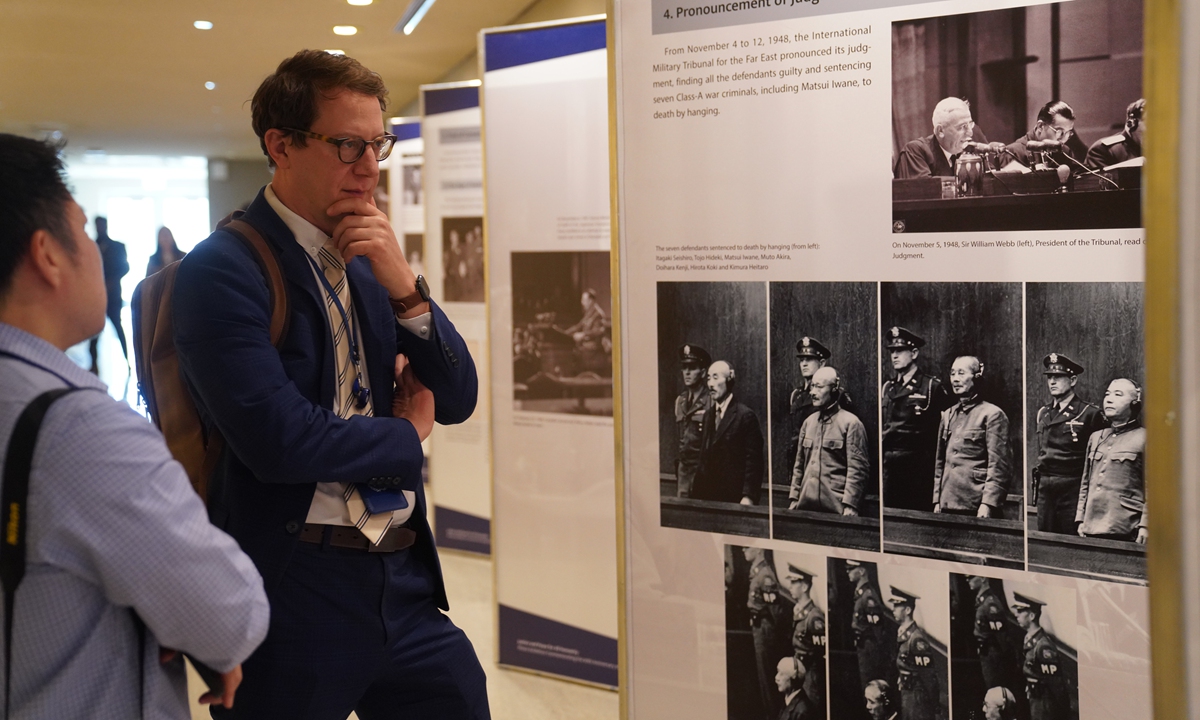 Visitors look at display panels at a photo exhibition themed 